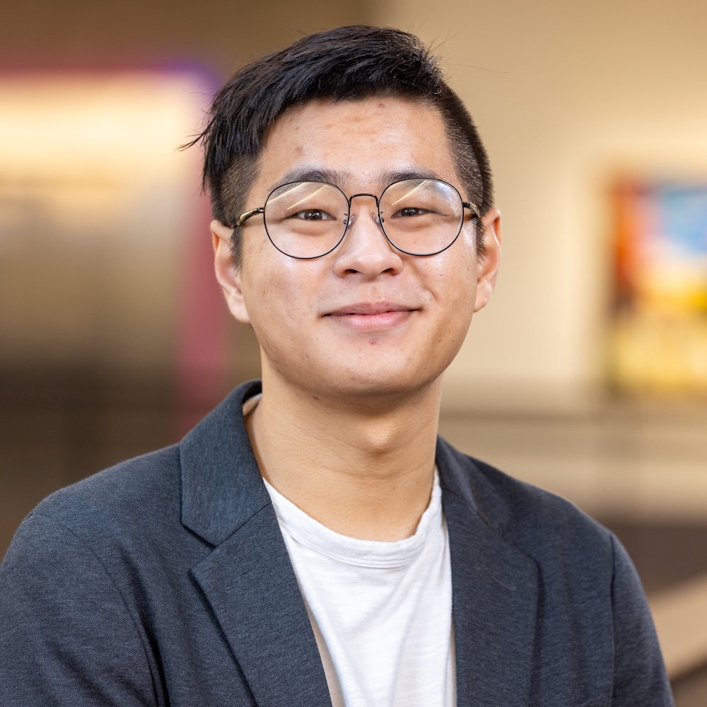 Matt Wang smiling in front of a polka dotted wall.