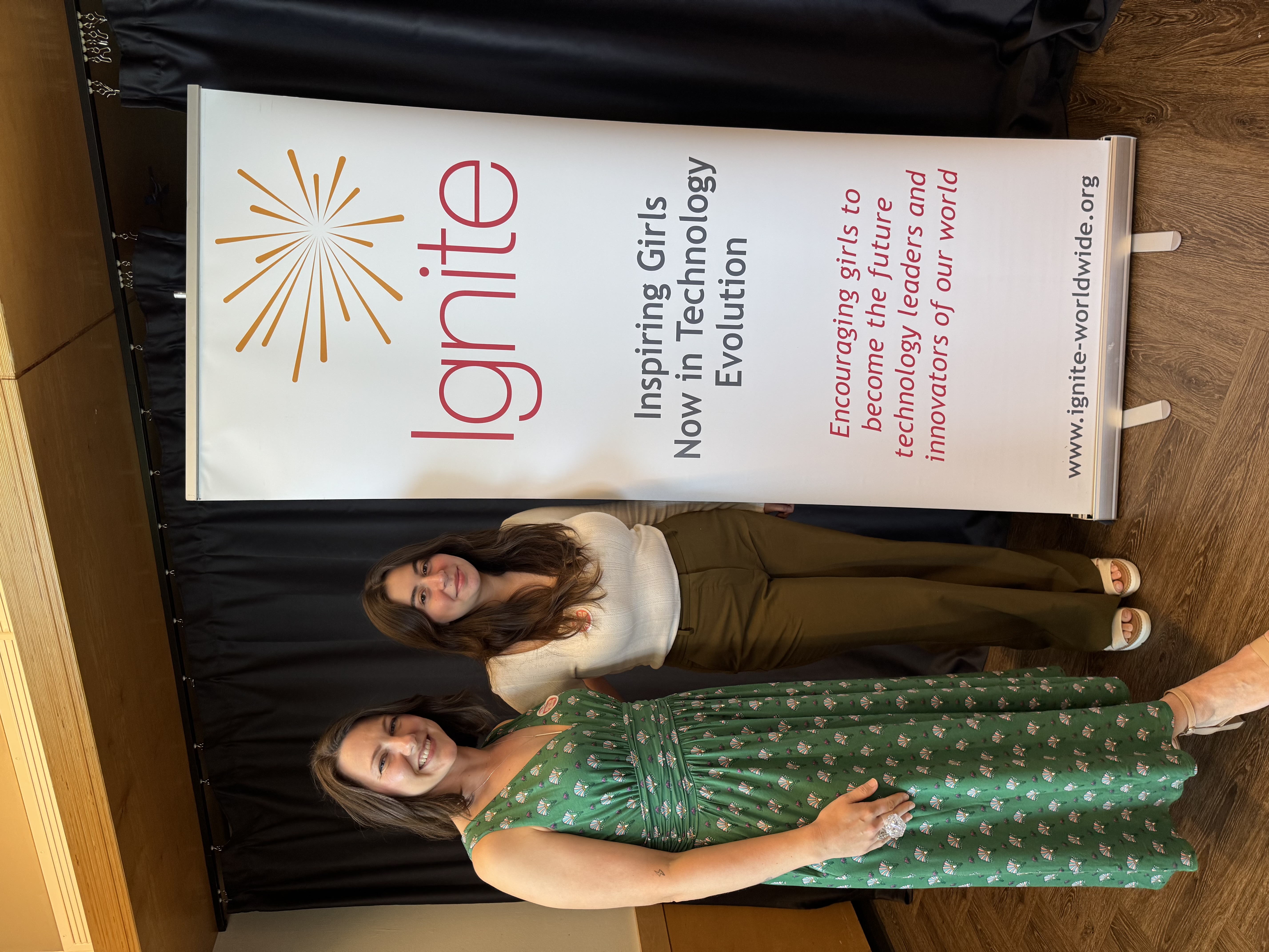 Laysha and Tasha standing side-by-side next to an IGNITE banner